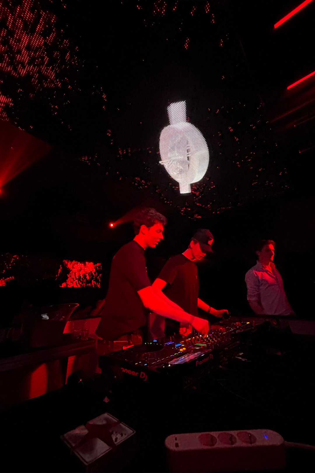 FØR U playing back to back under red club lights with a spinning mirror light above the booth